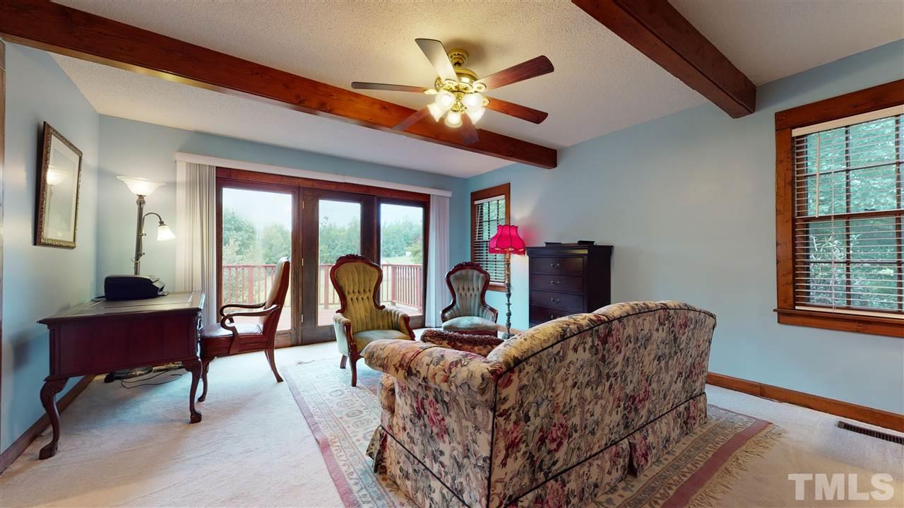 7010 Farmdale Road Raleigh, NC 27610 - Photo 21 of 30 a living room with furniture a chandelier and a large window