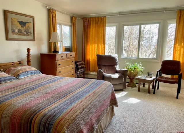 a bedroom with a bed and a couch next to a window