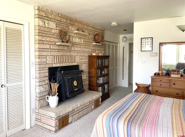 a spacious bedroom with a bed and a fireplace