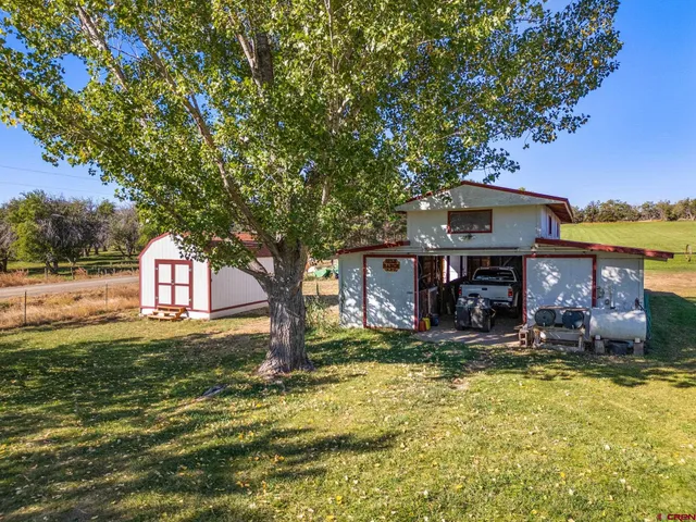 a view of a house with a yard tree and outdoor seating