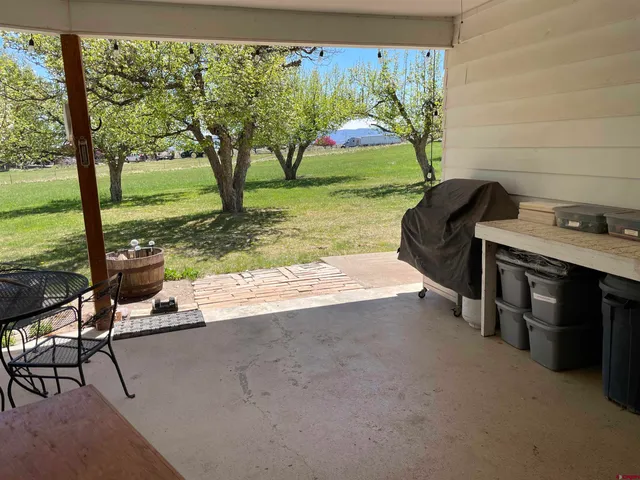 a view of a porch with furniture and a yard