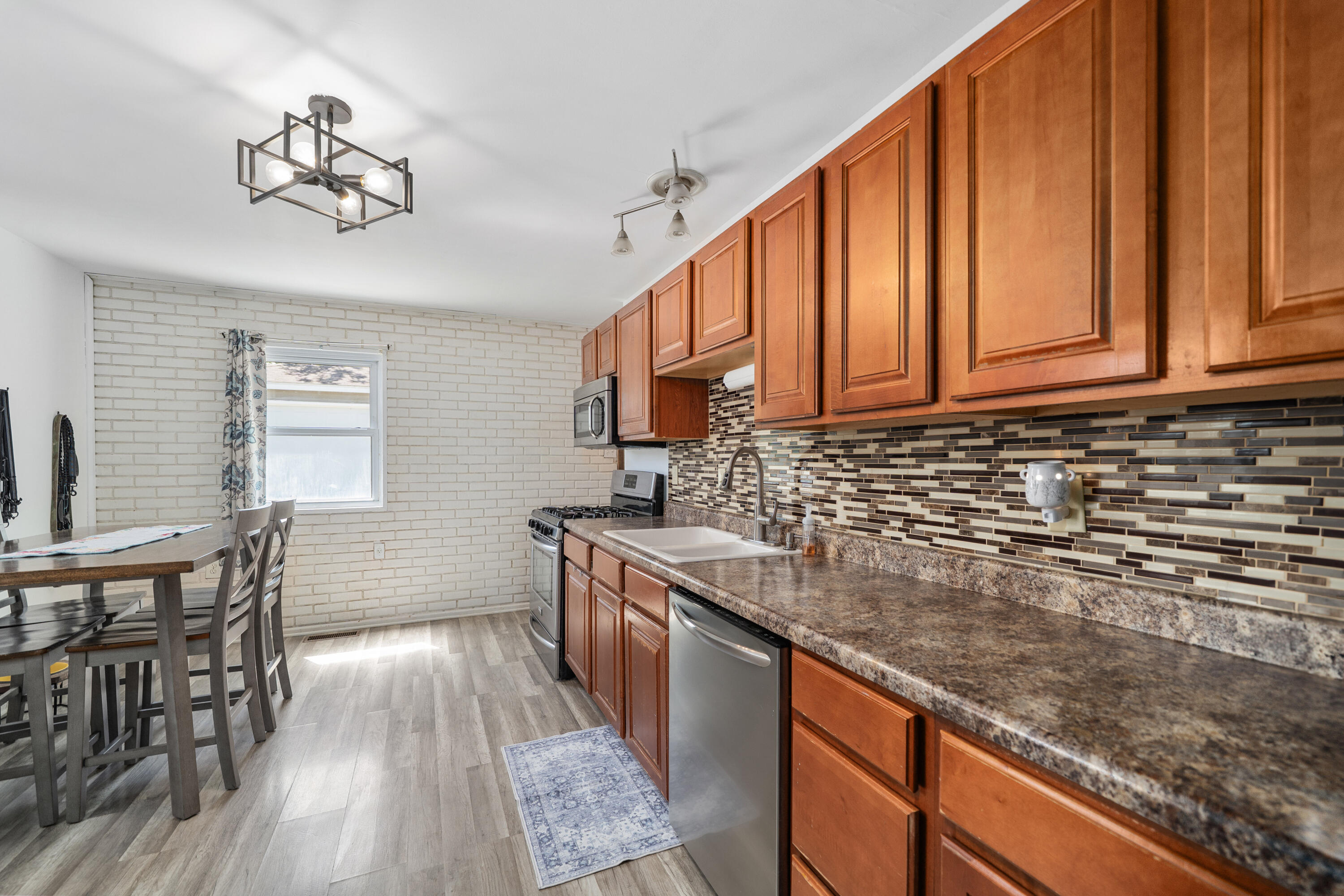 736-1 Imperial Road Valparaiso, IN 46385 - Photo 10 of 16 a kitchen with stainless steel appliances granite countertop a stove a sink dishwasher and microwave with wooden floor