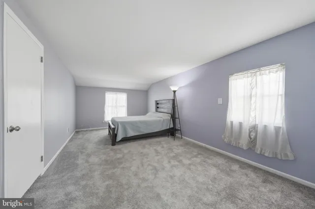 a bedroom with a bed and a lamp on the dresser