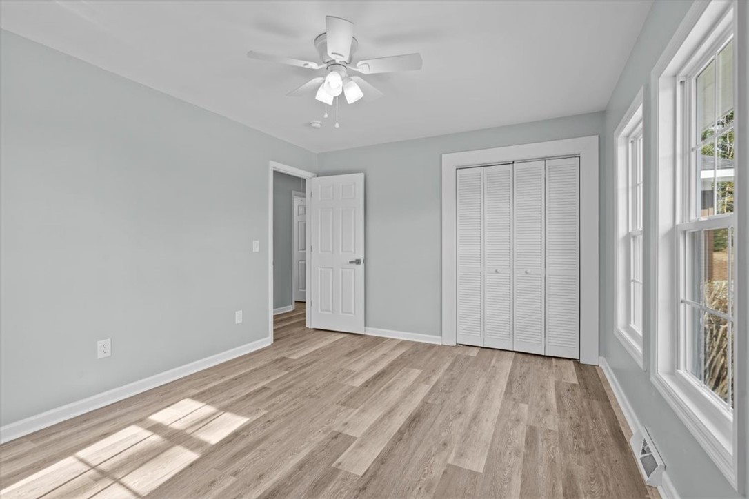 326 Kenneth Street Walhalla, SC 29691 - Photo 18 of 30 This airy bedroom features abundant natural light and durable flooring, offering a fresh and inviting atmosphere.