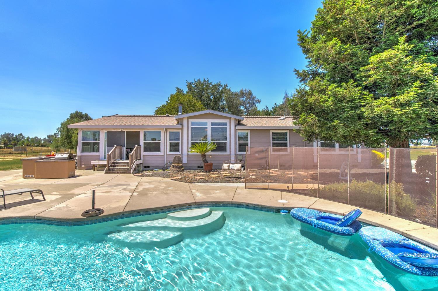12390 Hobday Road Wilton, CA 95693 - Photo 54 of 92 a view of a house with swimming pool and porch