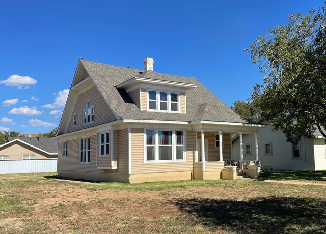 a house that has a big tree in front of it