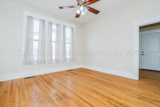 a view of a room with gym equipment and wooden floor