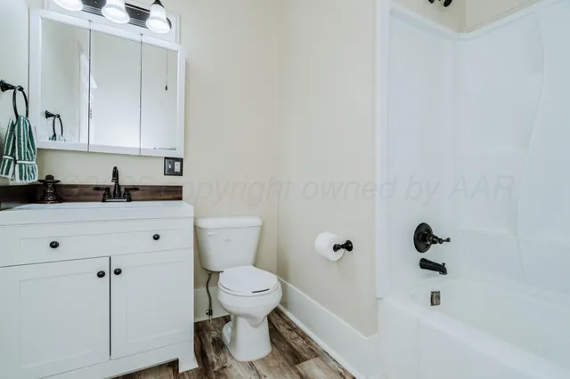 a view of a room with wooden floor and a ceiling fan