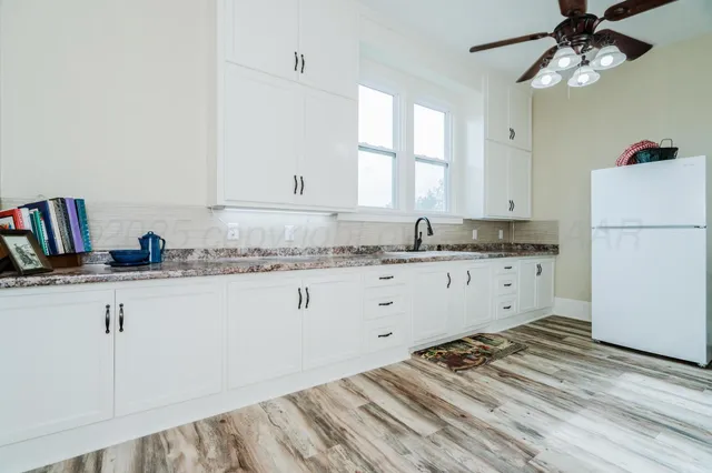 a view of a bedroom with a bed and wooden floor