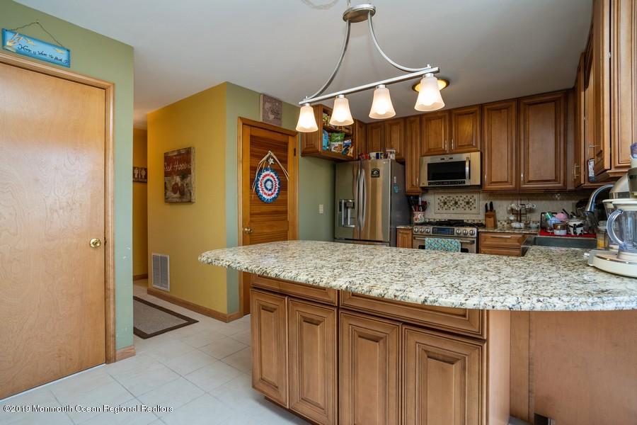 140 Cedar Run Road Bayville, NJ 08721 - Photo 4 of 18 a kitchen with stainless steel appliances granite countertop a sink a refrigerator and a wooden cabinets