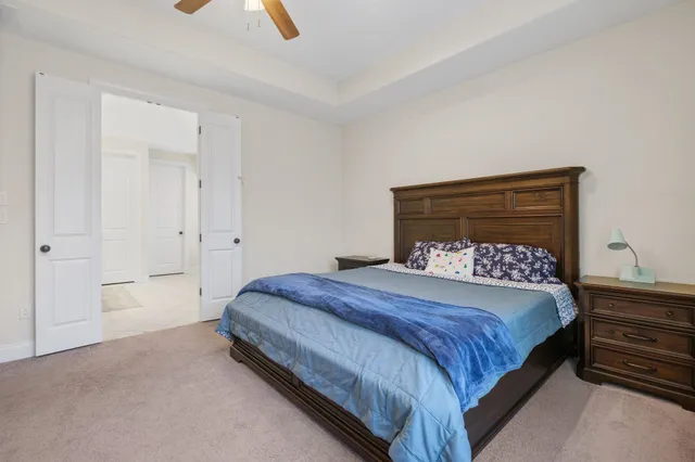 a bedroom with a bed couch and a ceiling fan