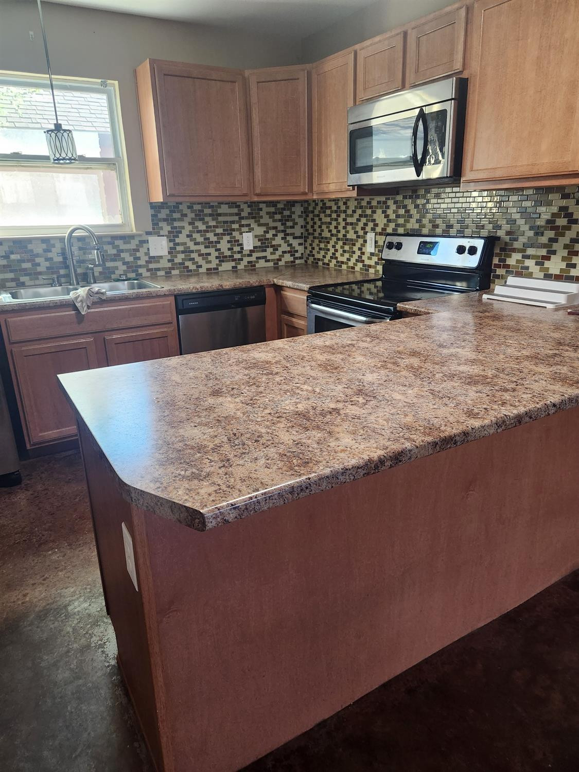 2109 21st Street, Unit 2 Lubbock, TX 79411 - Photo 7 of 21 a kitchen with kitchen island granite countertop a sink a stove top oven a counter space and cabinets