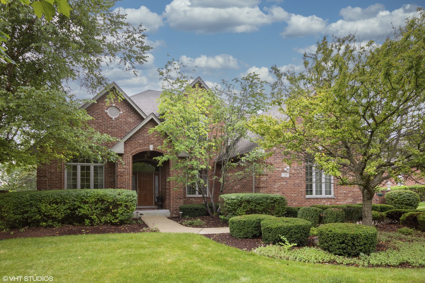 a front view of a house with a yard and outdoor seating