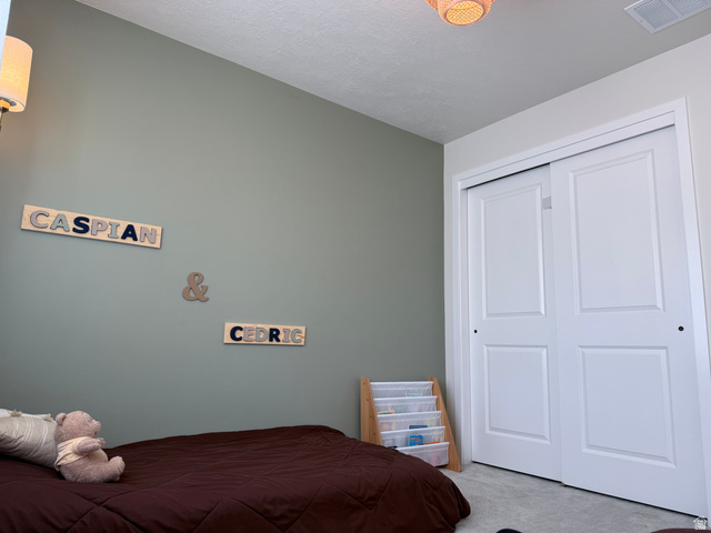774 West 480 South American Fork, UT 84003 - Photo 65 of 76 Room featuring a light green wall, white bi-fold closet doors, wall-mounted lighting fixture, and textured ceiling
