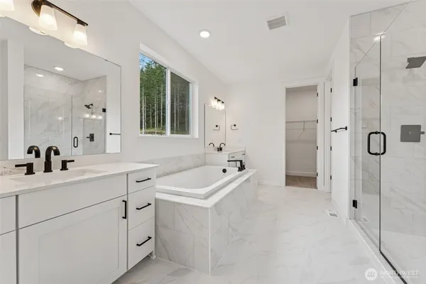 a spacious bathroom with a tub sink a shower and mirror