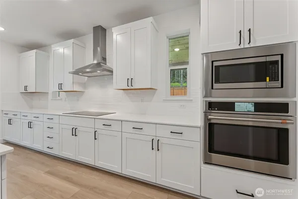 a kitchen with granite countertop white cabinets stainless steel appliances and sink