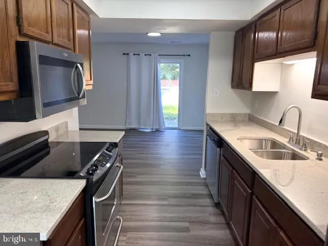 a kitchen with kitchen island granite countertop a sink appliances and cabinets