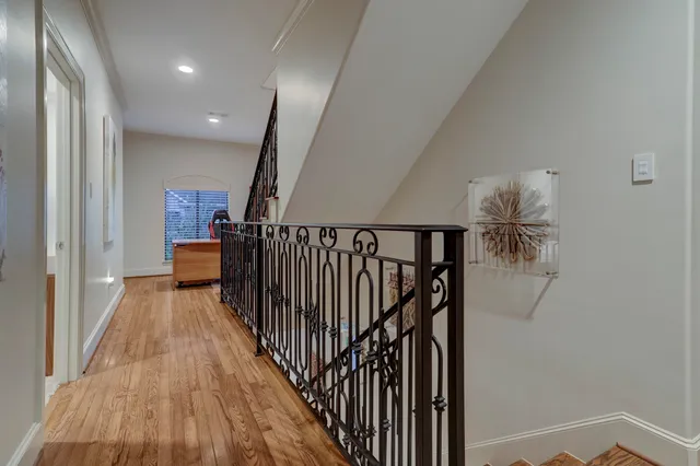 a view of a hallway with wooden floor and stairs