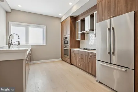 a kitchen with stainless steel appliances a refrigerator sink and cabinets
