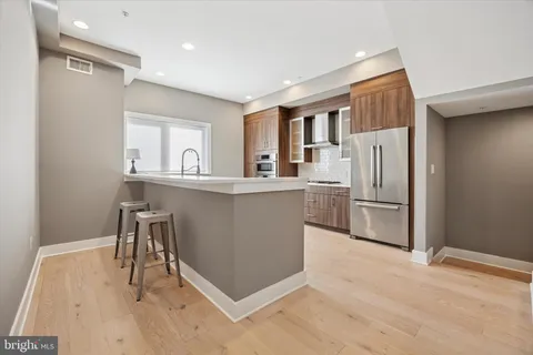 a kitchen with stainless steel appliances granite countertop a refrigerator and a stove top oven