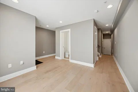 wooden floor in an empty room with a bathroom