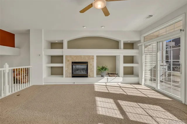 a living room with fireplace furniture and a ceiling fan