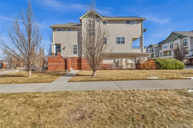 a front view of a house with cars parked