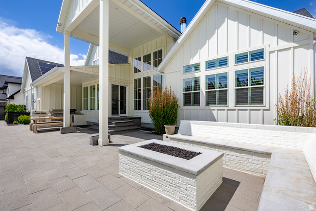 630 East Center Street Alpine, UT 84004 - Photo 101 of 115 Expansive paver patio featuring a built-in fire pit with stone surround, integrated bench seating, and an overhead covered porch