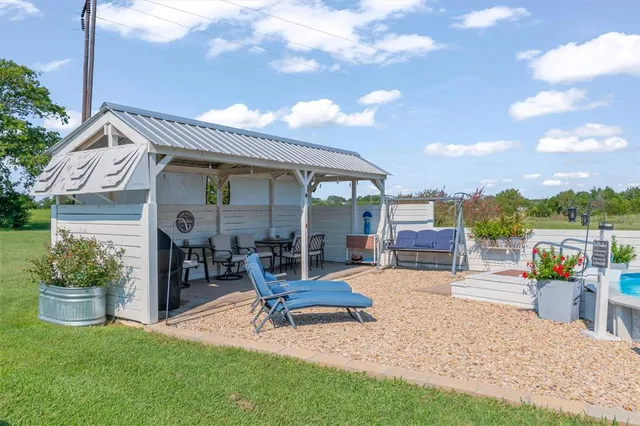a view of a house with backyard sitting area and garden
