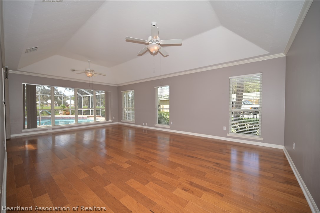 2737 Cheyenne Road Sebring, FL 33875 - Photo 18 of 50 a view of an empty room with wooden floor and a window