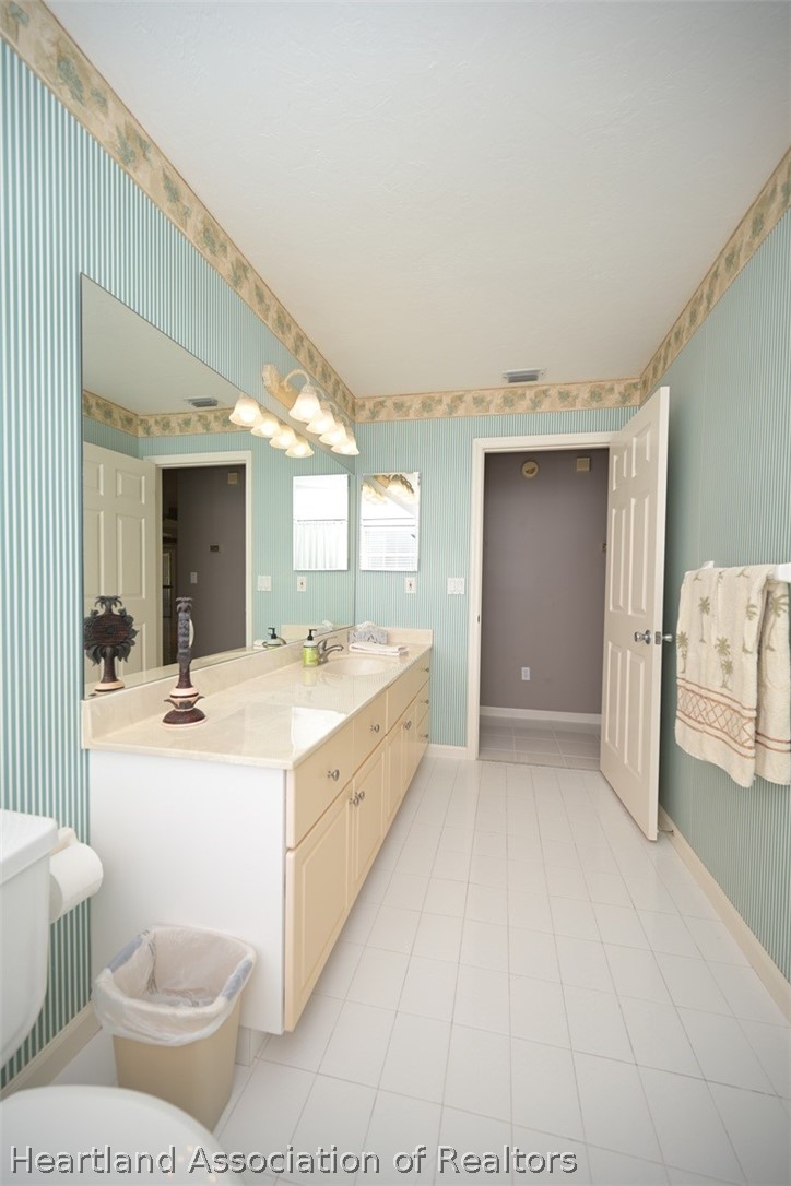 2737 Cheyenne Road Sebring, FL 33875 - Photo 27 of 50 a large white room with a large mirror vanity and toilet