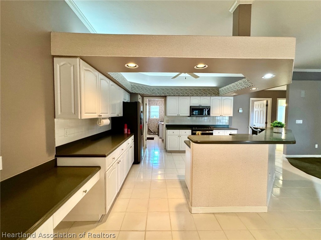 2737 Cheyenne Road Sebring, FL 33875 - Photo 8 of 50 a large kitchen with kitchen island a sink a counter top space and appliances
