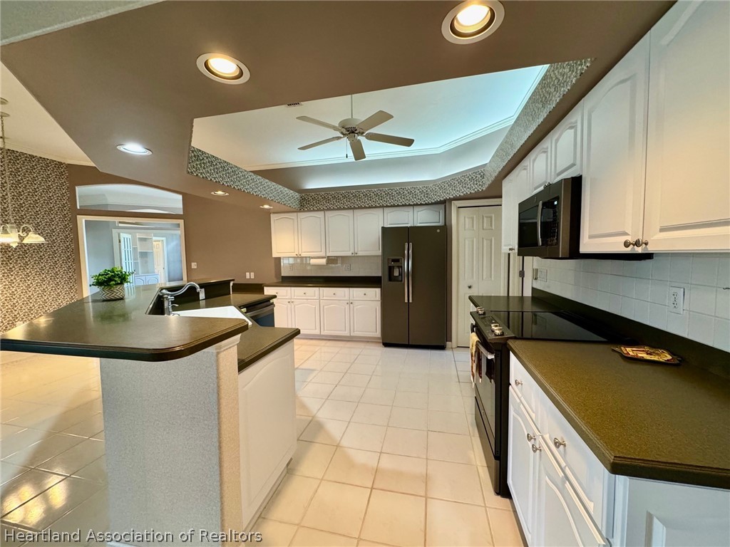 2737 Cheyenne Road Sebring, FL 33875 - Photo 10 of 50 a large kitchen with stainless steel appliances granite countertop a sink and a refrigerator