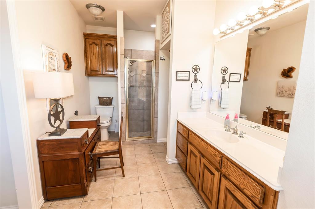 2168 Fruitland Road Sunset, TX 76270 - Photo 32 of 40 a bathroom with a sink double vanity and a mirror