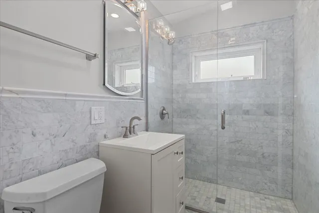 a bathroom with a sink a toilet and shower