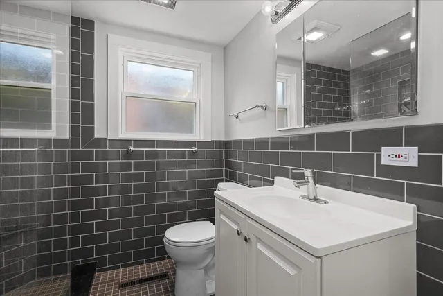 a bathroom with a sink a toilet and a mirror