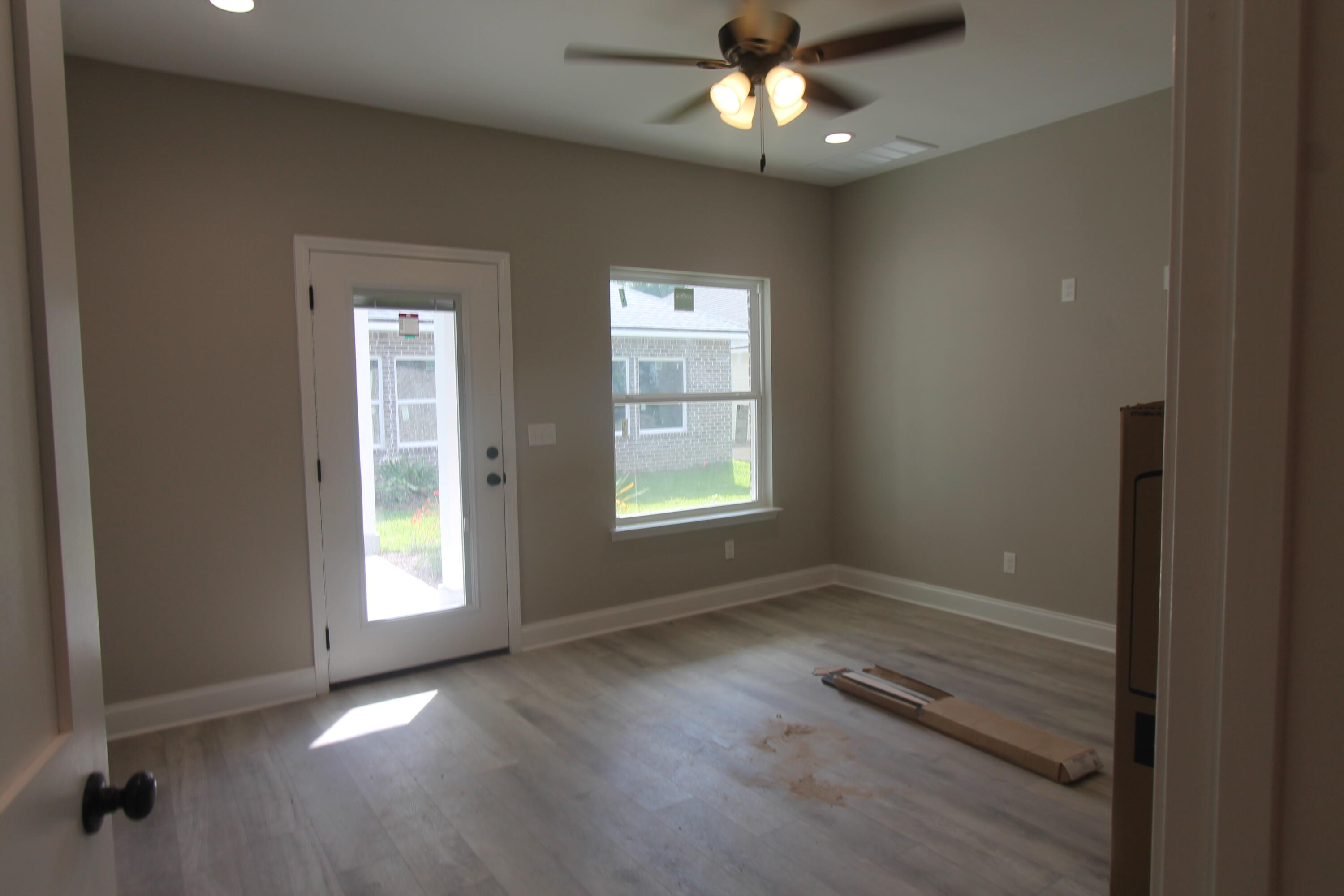 33 8th Avenue Shalimar, FL 32579 - Photo 12 of 13 an empty room with wooden floor chandelier fan and windows