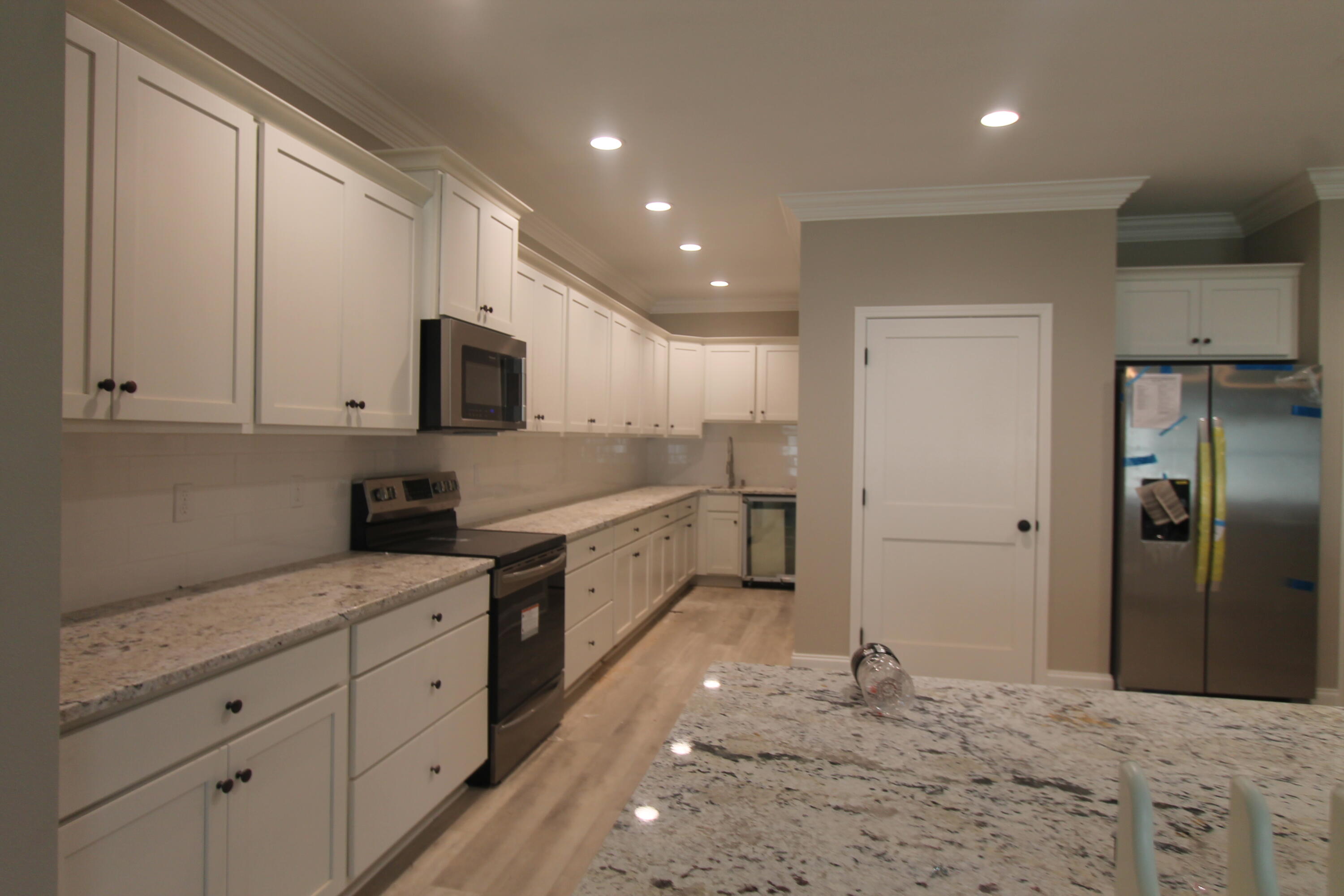 33 8th Avenue Shalimar, FL 32579 - Photo 4 of 13 a large white kitchen with granite countertop white cabinets and stainless steel appliances