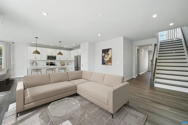 a living room with furniture and view of kitchen