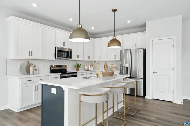 a kitchen with a sink a microwave and wooden floor