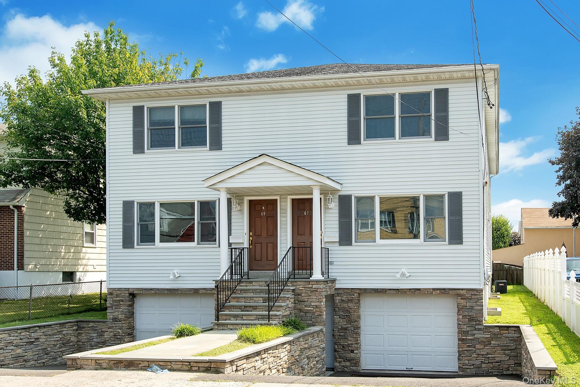 View of front of home with a garage and stone siding