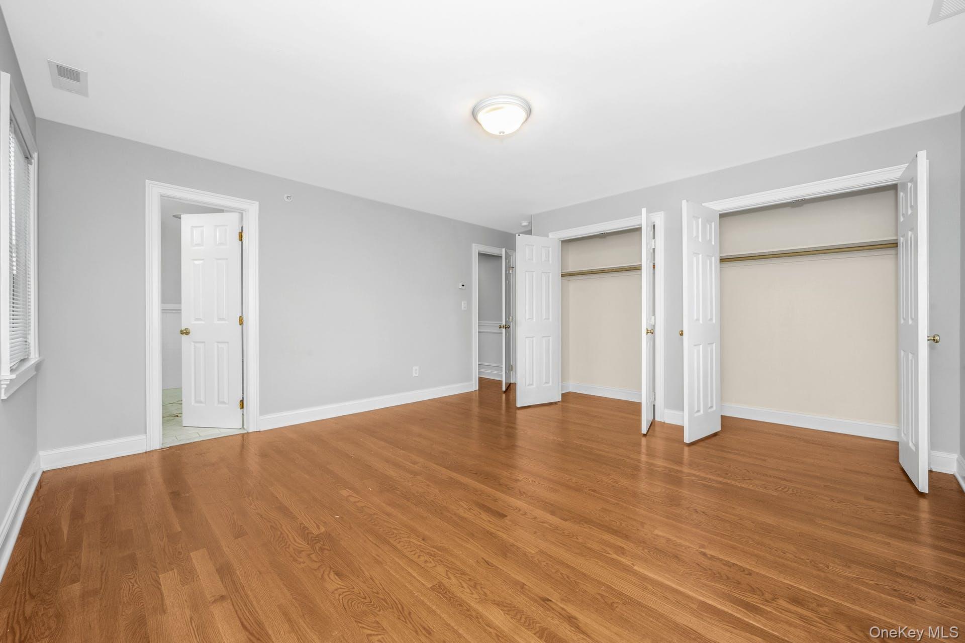 69 Ellsworth Avenue Harrison, NY 10528 - Photo 16 of 28 Unfurnished bedroom with two closets and wood finished floors