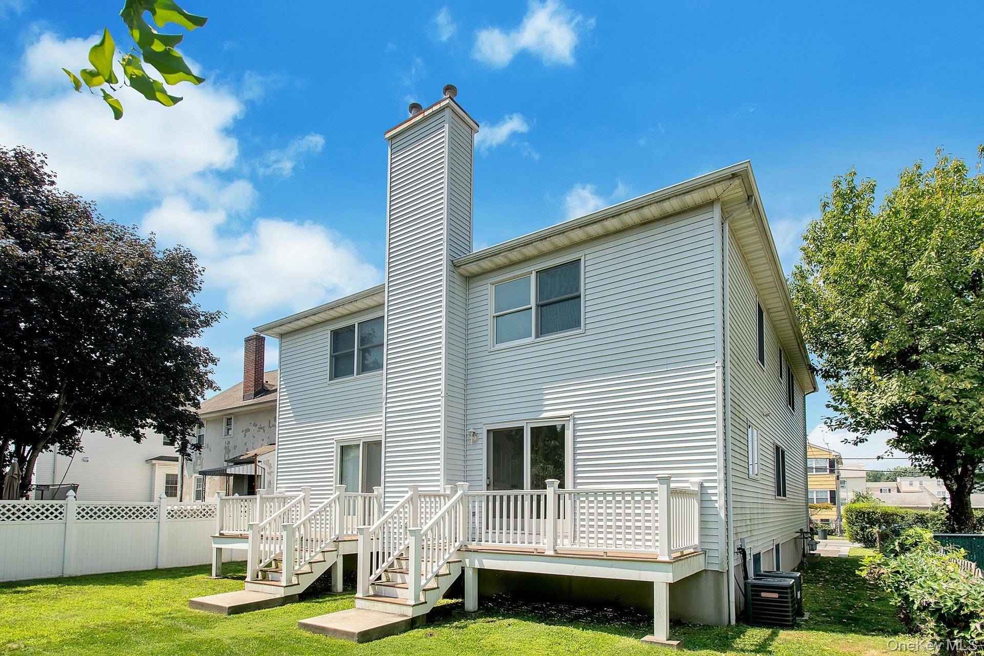 69 Ellsworth Avenue Harrison, NY 10528 - Photo 26 of 28 Rear view of property featuring a chimney, a wooden deck, and stairway