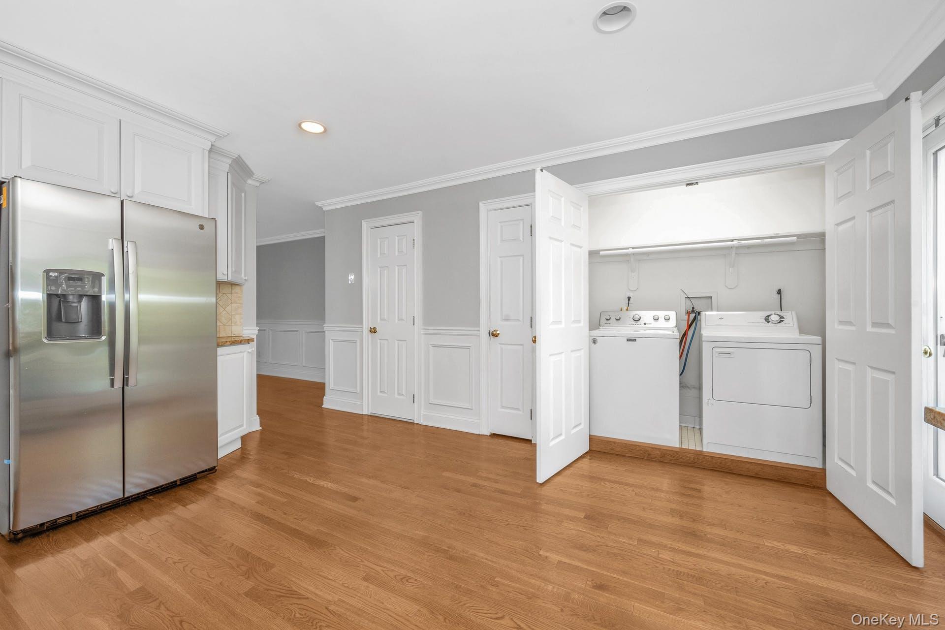 69 Ellsworth Avenue Harrison, NY 10528 - Photo 10 of 28 Washroom featuring independent washer and dryer, ornamental molding, recessed lighting, light wood-style floors, and a wainscoted wall