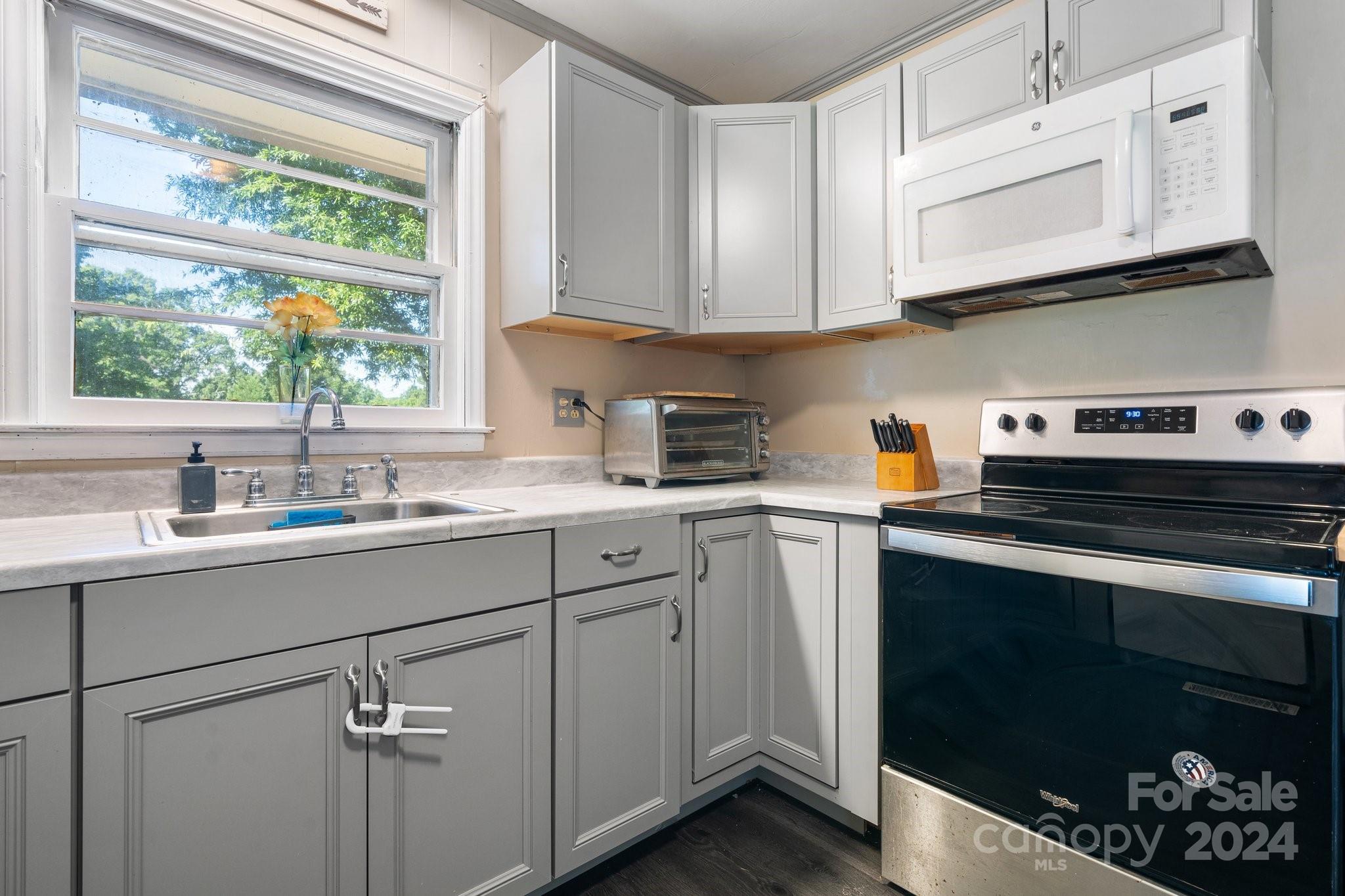 1675 Morningside Drive Newton, NC 28658 - Photo 12 of 36 a kitchen with stainless steel appliances granite countertop a sink a stove and a microwave