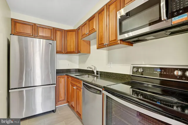 a kitchen with stainless steel appliances granite countertop a refrigerator and a sink