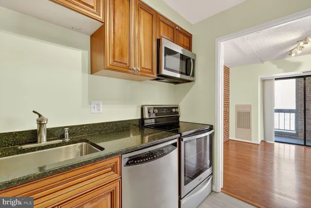 a kitchen with stainless steel appliances granite countertop a sink a stove and microwave