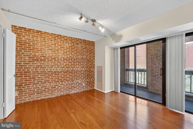 a view of empty room with wooden floor and floor to ceiling window