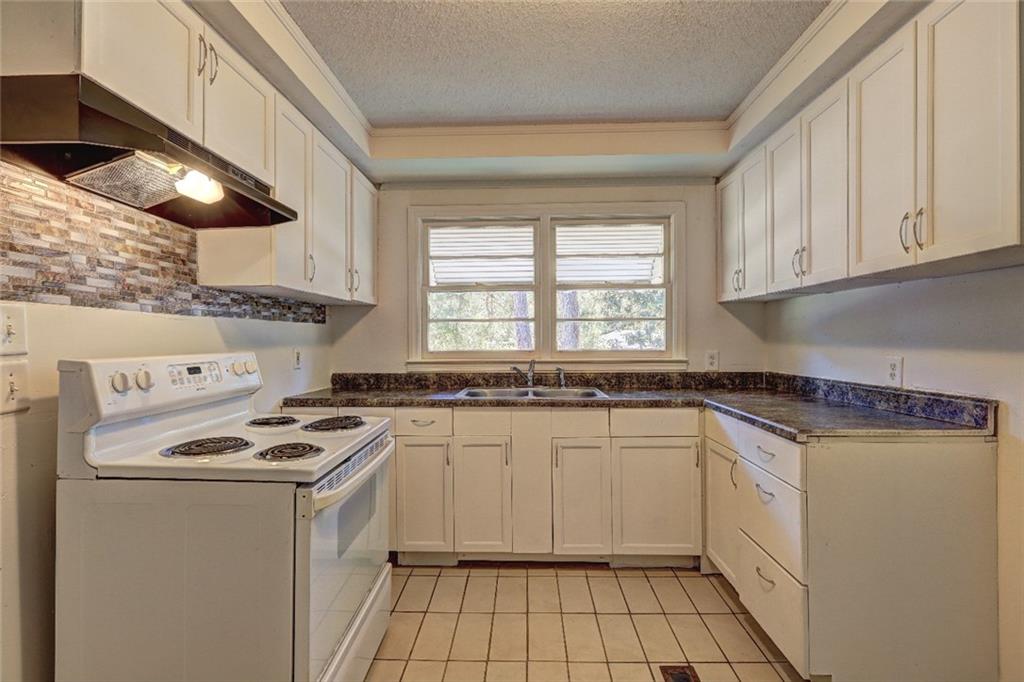 2128 Knightsbridge Road Macon, GA 31211 - Photo 5 of 12 a kitchen with stainless steel appliances granite countertop a stove a sink and a microwave