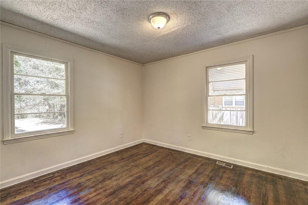 2128 Knightsbridge Road Macon, GA 31211 - Photo 7 of 12 a view of an empty room with wooden floor and a window